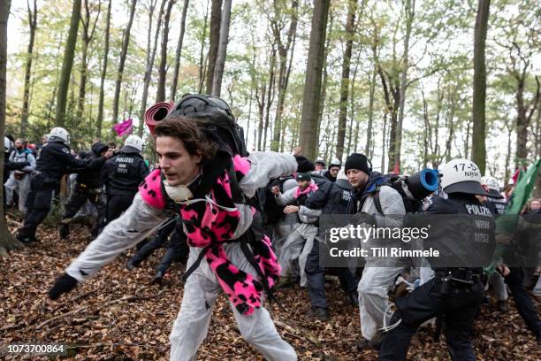 Police officers try to stop the march of environmental activists of 'Ende Gelaende' as they protest for the preservation of the ancient forest...