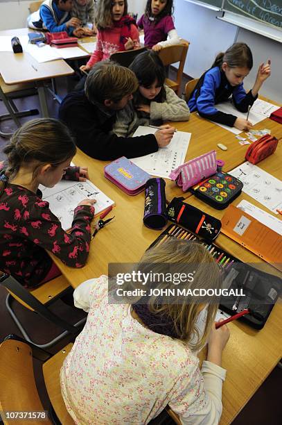 Pupils at work with their teacher during a math class in a primary school in Berlin December 7, 2010. The three-yearly OECD Programme for...