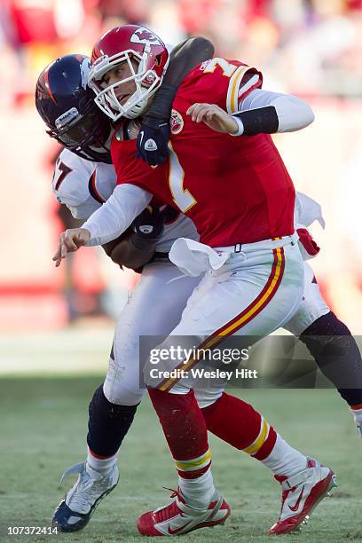 Matt Cassel of the Kansas City Chiefs is hit after throwing a pass by Justin Bannan of the Denver Broncos on December 5, 2010 at Arrowhead Stadium in...