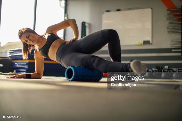 young woman exercising in gym - de rola imagens e fotografias de stock