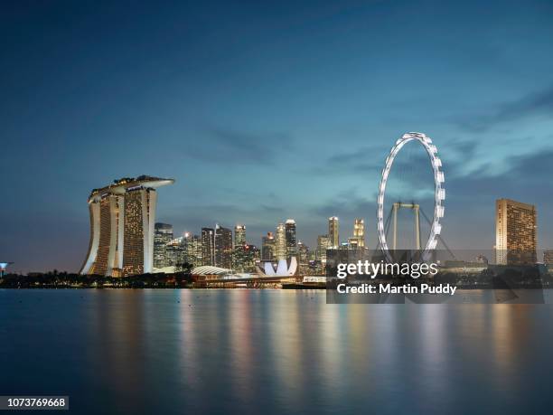 the singapore skyline and financial district at dusk, elevated view - singapore flyer stock-fotos und bilder