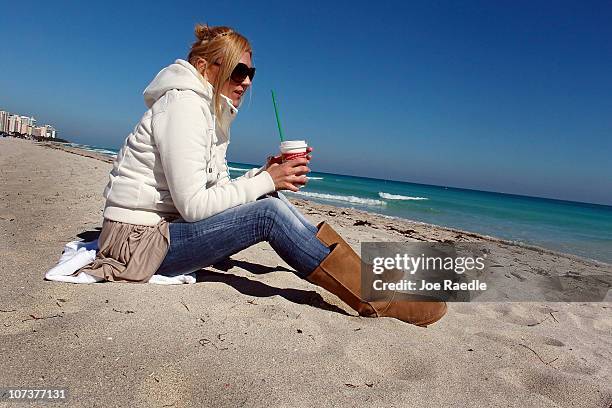 Anna Szabunia on vacation from Poland wears a jacket and boots as she stays warm while sitting on the beach on December 7, 2010 in Miami Beach,...