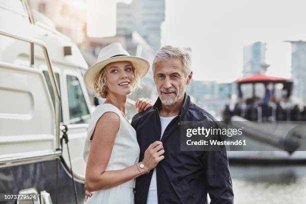 older man and young woman at a marina next to a yacht - old man young woman stockfoto's en -beelden