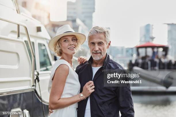 older man and young woman at a marina next to a yacht - idade humana imagens e fotografias de stock