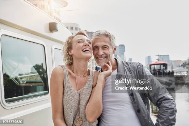 happy older man and young woman on jetty next to yacht - old man young woman stockfoto's en -beelden