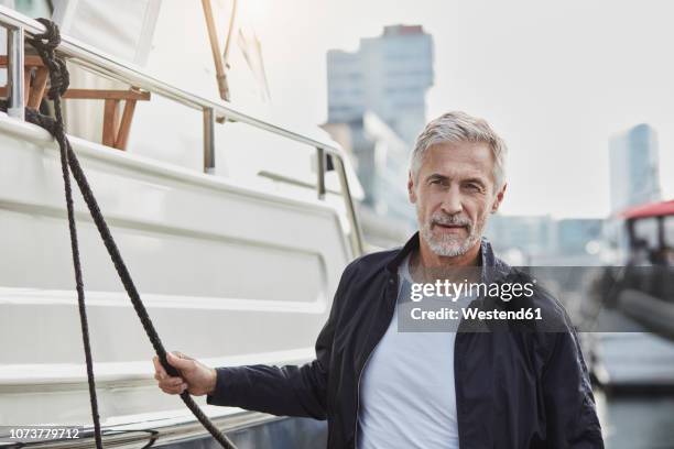 confident mature man at a marina next to a yacht - rich people imagens e fotografias de stock