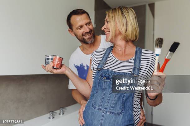 happy pregnant couple about to paint their home - flat renovation stock pictures, royalty-free photos & images