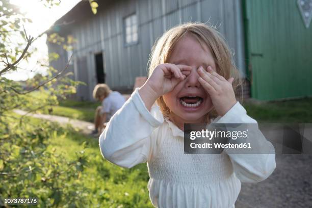 portrait of screaming little girl covering eyes with her hands - crying sibling stock pictures, royalty-free photos & images