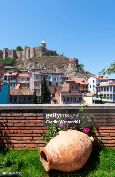 georgia, tbilisi, narikala fortess with flowers and amphora in foreground - amphore photos et images de collection
