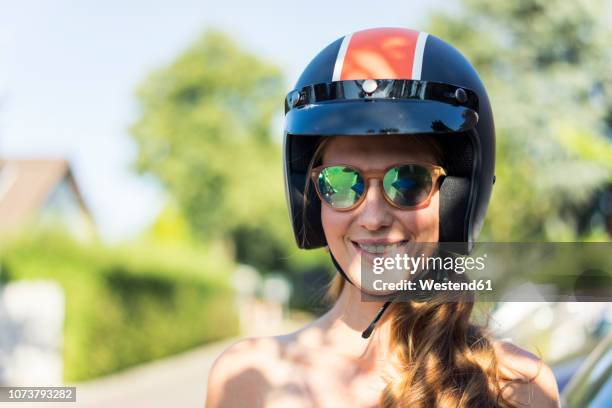 portrait of smiling woman wearing sunglasses and motorcycle helmet - crash helmet stock pictures, royalty-free photos & images