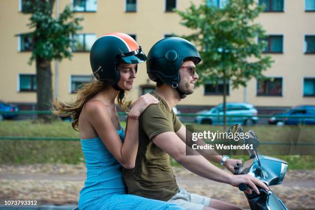 couple riding motor scooter in the city - lambreta imagens e fotografias de stock