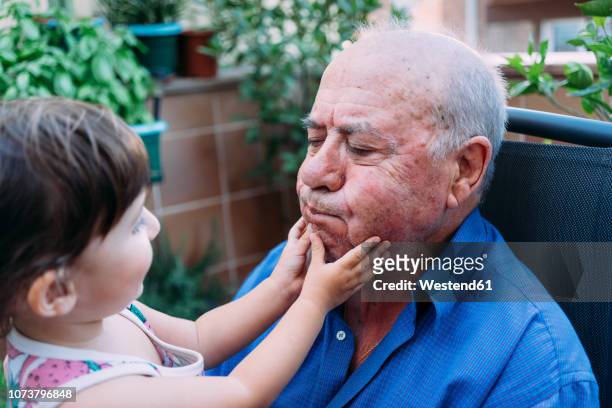 grandfather and baby girl playing together on the terrace - baby grandpa imagens e fotografias de stock