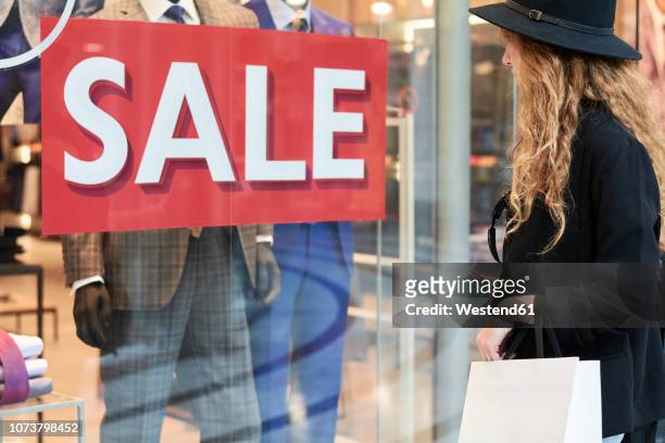 stylish red head millennial wearing a hat going shopping inside of a mall - retail signage stock pictures, royalty-free photos & images