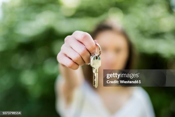 close-up of woman holding key - house keys stock-fotos und bilder