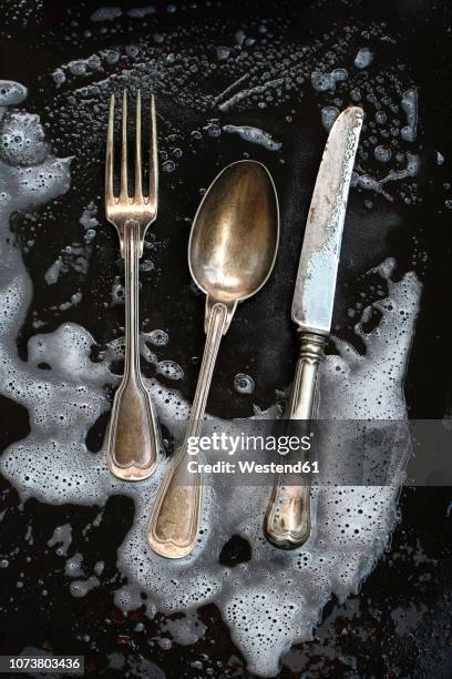 silver cutlery getting cleaned - bestek stockfoto's en -beelden