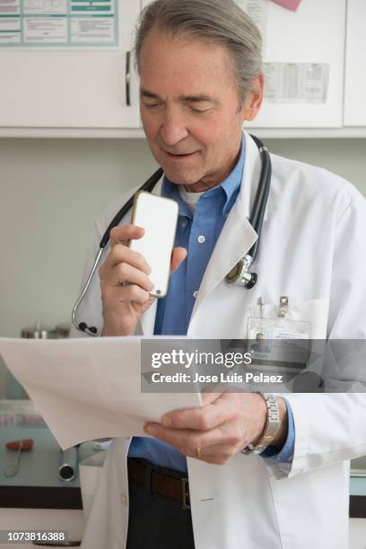 doctor dictating patient notes to a smartphone - doctor with male patient reading notes stock pictures, royalty-free photos & images