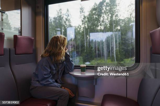 woman traveling by train looking out of window - reflection in train window stock pictures, royalty-free photos & images