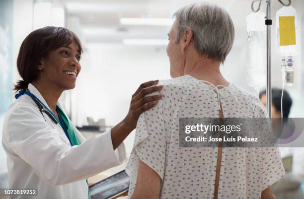 doctor showing exam result to senior patient using digital tablet - exam hall stock-fotos und bilder