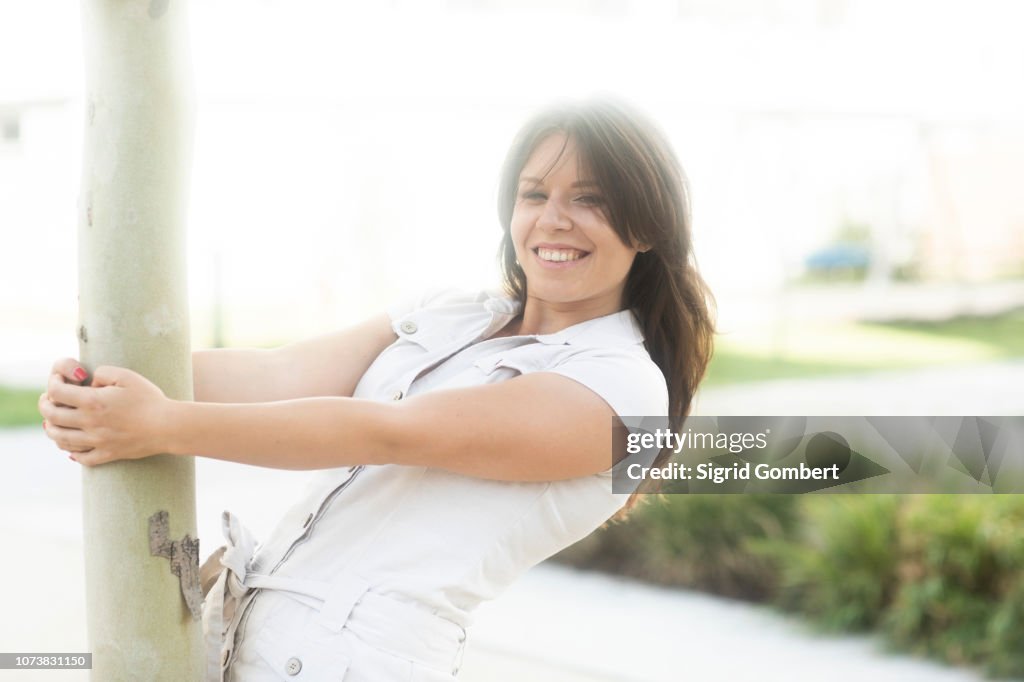 Woman hanging onto tree