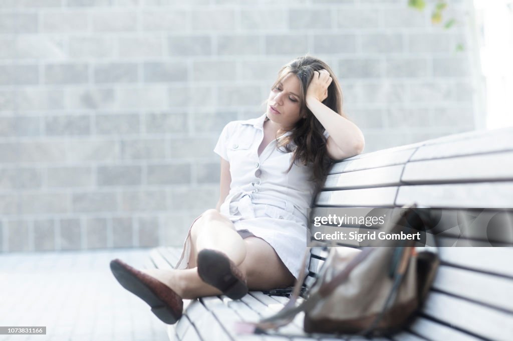 Woman on bench looking tired