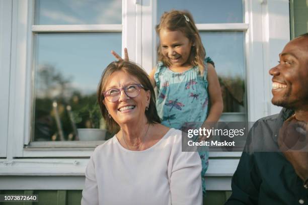 happy multi-generation family against window at porch - father son outdoor celebration photos et images de collection