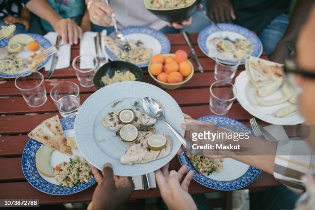 high angle view of multi-generational family having lunch at table - black man high 5 stockfoto's en -beelden