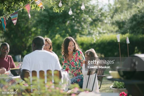 happy multi-generation family having lunch together at patio during garden party - medium group of people stock pictures, royalty-free photos & images