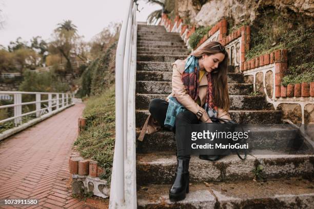 young woman searching on her bag - purse contents stock pictures, royalty-free photos & images