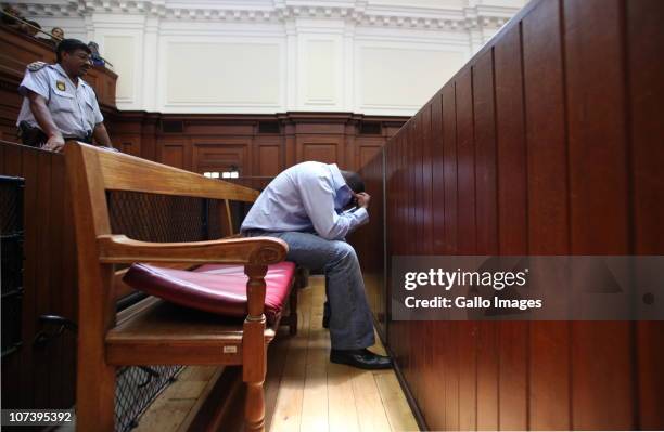 Zola Tongo, one of three people originally charged with the Anni Dewani's killing, covers his face in the Cape Town High Court, on December 7, 2010...