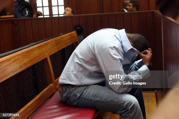 Zola Tongo, one of three people originally charged with the Anni Dewani's killing, covers his face in the Cape Town High Court, on December 7, 2010...