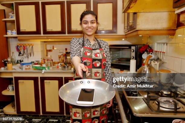 a teenager girl cooking a cell phone - pakistani people stock pictures, royalty-free photos & images