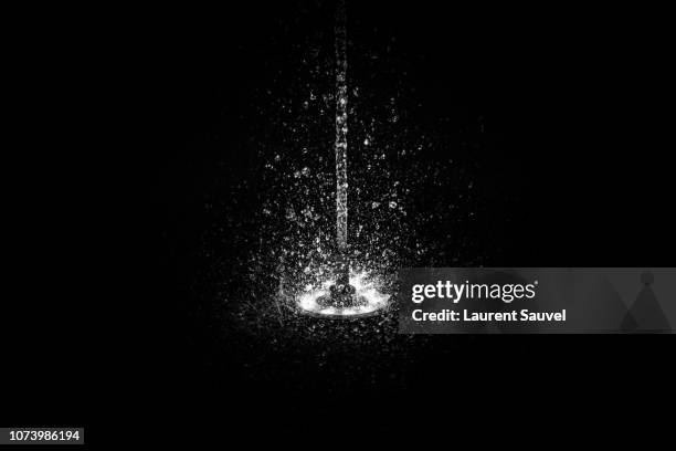 black and white fountain jet of water splashing - fontein stockfoto's en -beelden