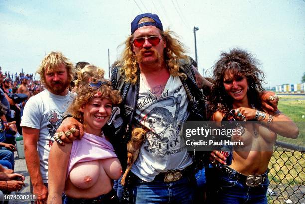 Before and after , a Harley Davidson bike rider carrying two Chihuahua's and his arms around two girls walks through the The Harley-Davidson...