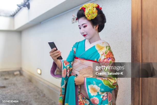 maiko apprentice geisha using smart phone during short break - geisha in training stock pictures, royalty-free photos & images