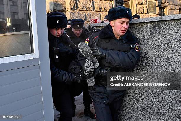 Police officers detain a protester as human rights activists gather on December 16, 2018 outside the headquarters of the FSB security service,...