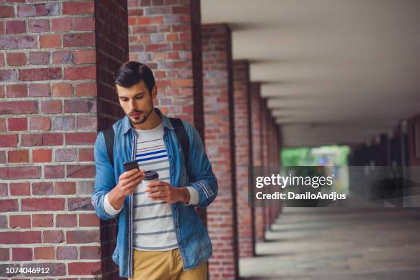 schön lässig junger mann in der stadt mit seinem smartphone - international student day stock-fotos und bilder