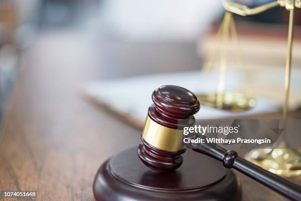 justice scales and books and wooden gavel - gerechtigkeit stock-fotos und bilder