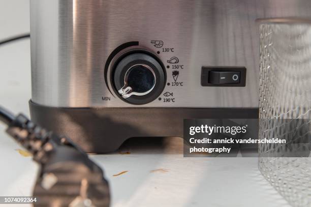power cord in front of deep fryer - schalter stock-fotos und bilder