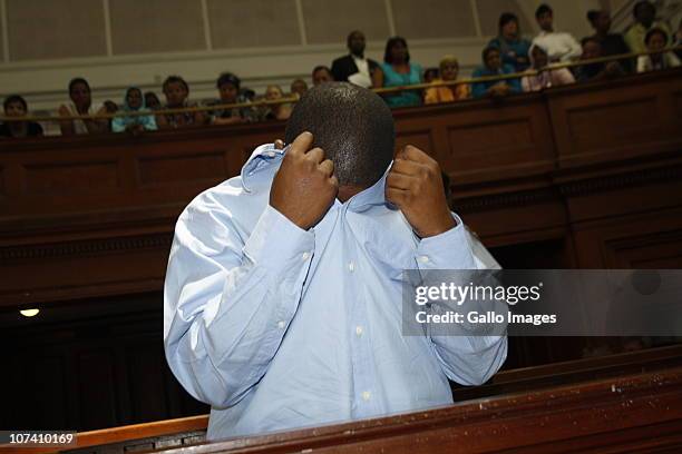Zola Tongo, one of three people originally charged with the Anni Dewani's killing, covers his face in the Cape Town High Court, on December 7, 2010...