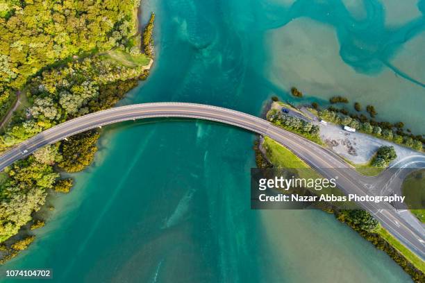 top looking down at bridge over waiwera river. - bridge stock pictures, royalty-free photos & images