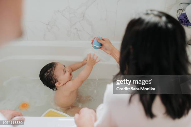 mother with daughter at bath time - kid bath mother stock-fotos und bilder