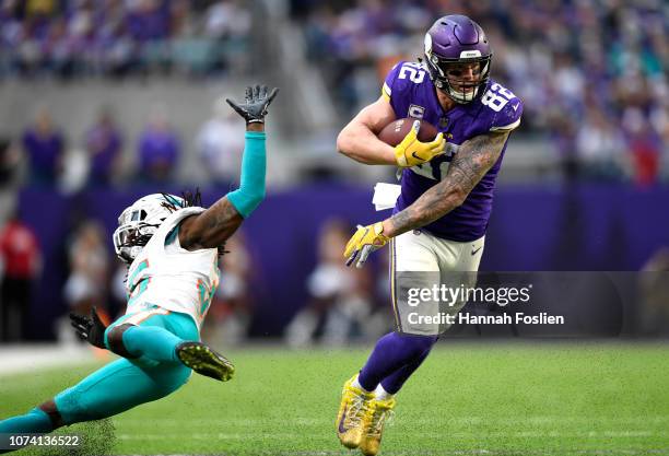 Kyle Rudolph of the Minnesota Vikings avoids a tackle by Walt Aikens of the Miami Dolphins in the third quarter of the game at U.S. Bank Stadium on...