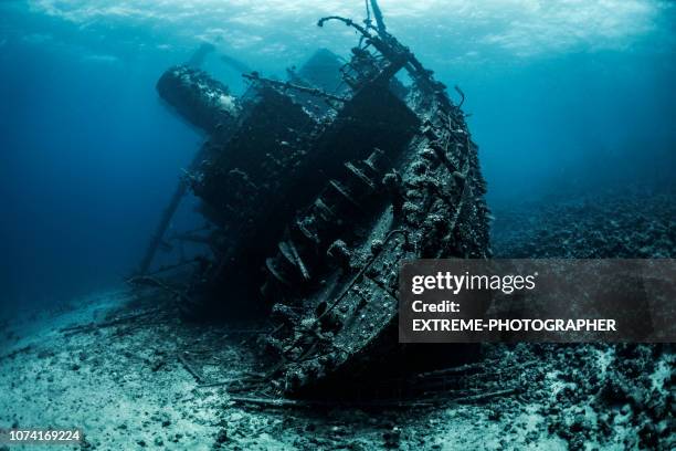 schipbreuk liggend op de bodem van de rode zee volledig wordt bedekt door zeewier en koralen - sunken stockfoto's en -beelden