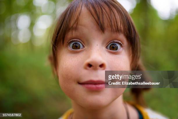 portrait of a wide-eyed girl standing outdoors, united states - child face foto e immagini stock