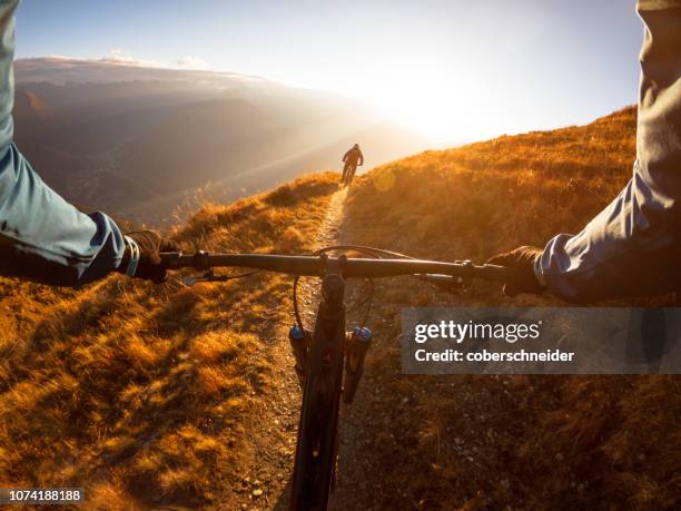 personal perspective shot of a man mountain biking with a friend in the alps, gastein, salzburg, austria - perspective is everything stock-fotos und bilder