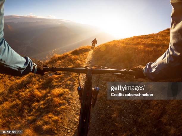 personal perspective shot of a man mountain biking with a friend in the alps, gastein, salzburg, austria - extreme sports point of view stock pictures, royalty-free photos & images