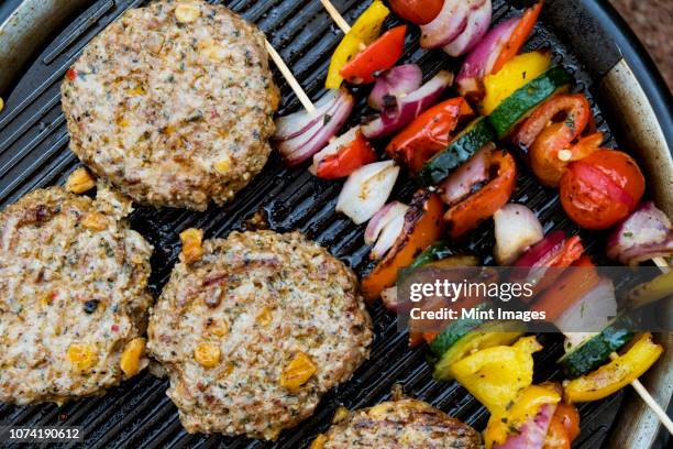 food on a barbeque, vegetable kebabs and home made burgers, cooking outdoors. - bbq smoker stock pictures, royalty-free photos & images