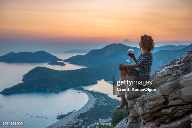 woman watching sunset. woman drinking wine. - ölüdeniz stock pictures, royalty-free photos & images