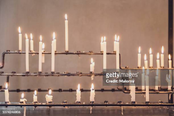 burning candles in a church. - church inside stock-fotos und bilder