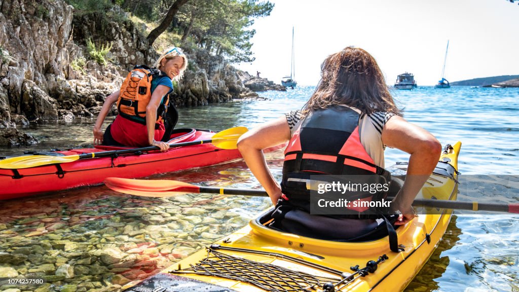 Kayakers rowing together in sea
